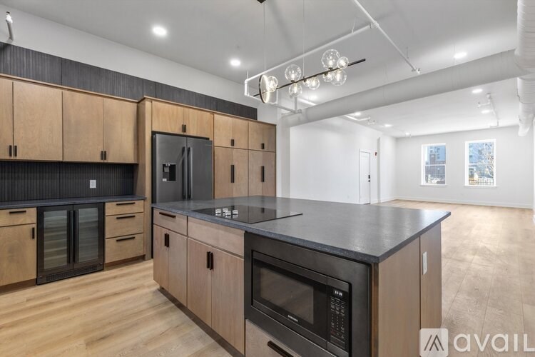 A modern kitchen with wooden cabinets and black countertops.