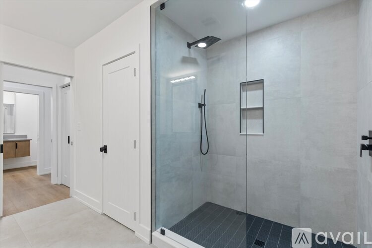 A bathroom with a walk-in shower and a glass door.