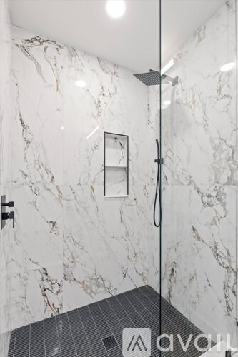 A marble bathroom with a walk in shower.