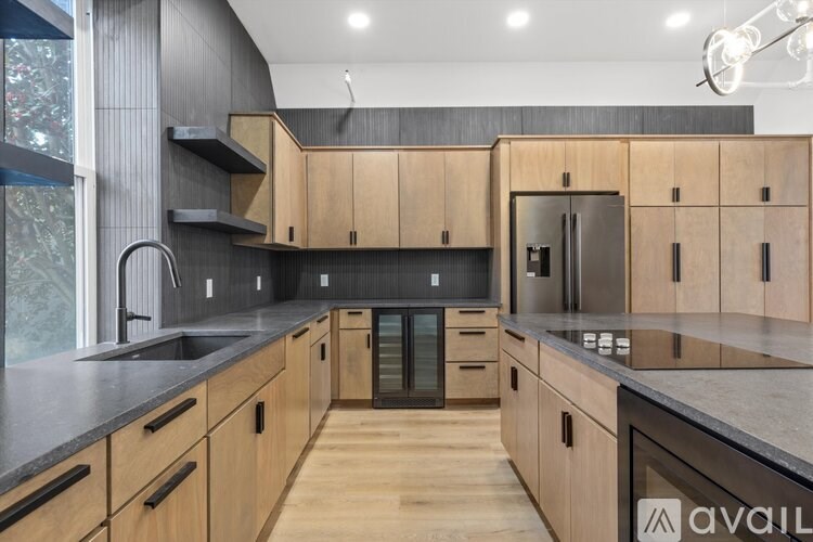 A modern kitchen with wooden cabinets and a black countertop.