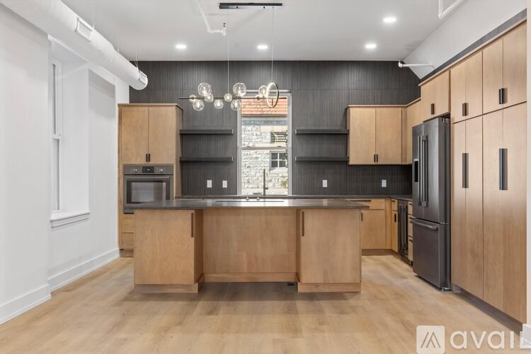 A kitchen with wooden cabinets and a black countertop.