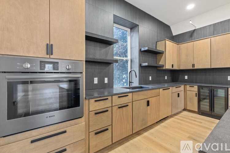 A modern kitchen with wooden cabinets and a stainless steel oven.