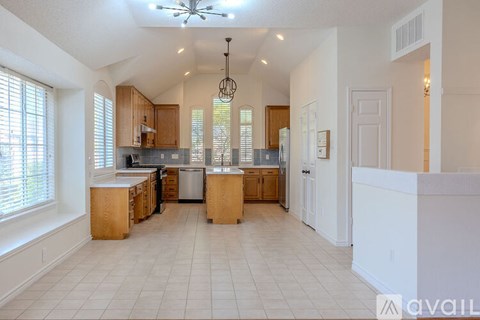 A spacious kitchen with wooden cabinets and a central island.