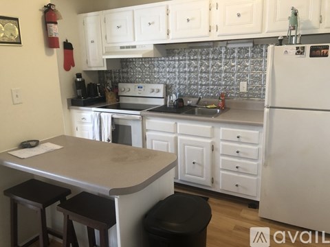 A kitchen with white cabinets and a black counter top.