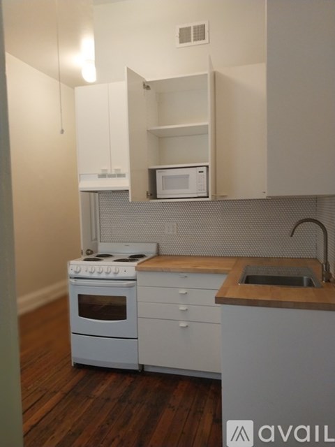 A kitchen with white cabinets and a wooden countertop.