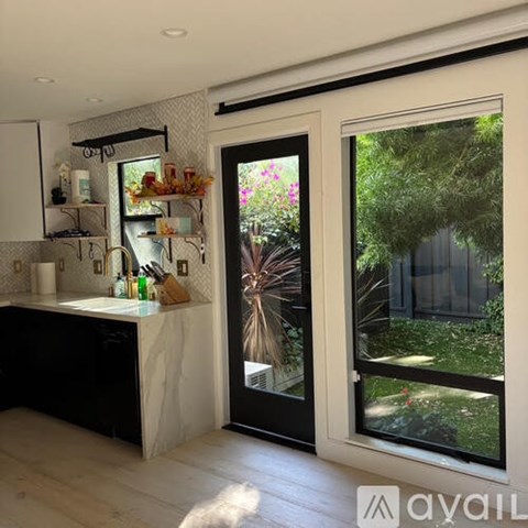 A kitchen with a sink and a window with a view of a garden.