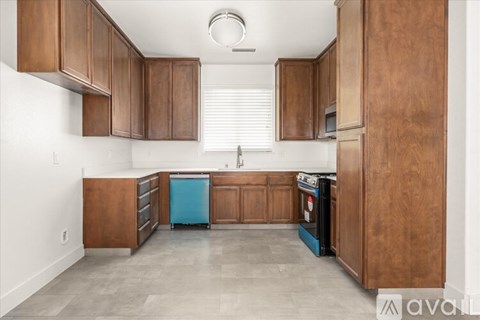 A kitchen with wooden cabinets and a blue dishwasher.