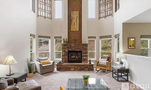 A living room with a fireplace and a painting above it.
