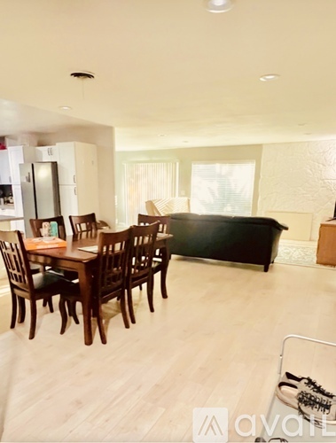 A dining room with a wooden table and chairs.