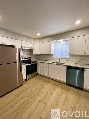 A kitchen with a refrigerator, stove, and dishwasher.