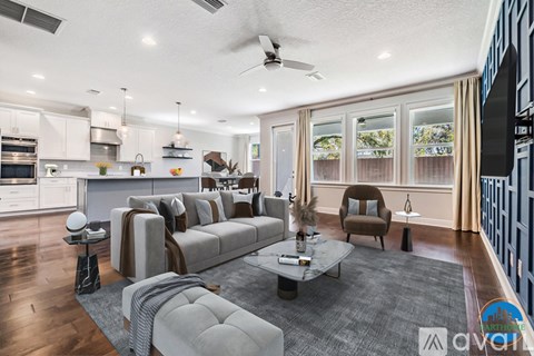 A modern living room with a grey sofa and a grey rug.