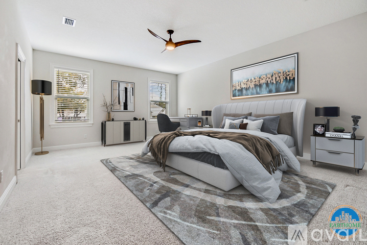 A bedroom with a large bed and a ceiling fan.