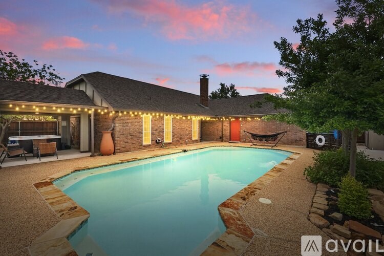 A house with a pool and lights around it.