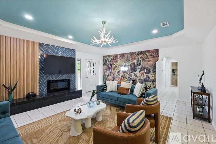 A living room with a blue couch and a fireplace.