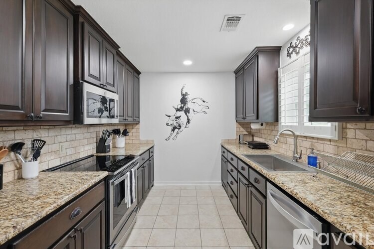 A kitchen with dark wood cabinets and granite countertops.
