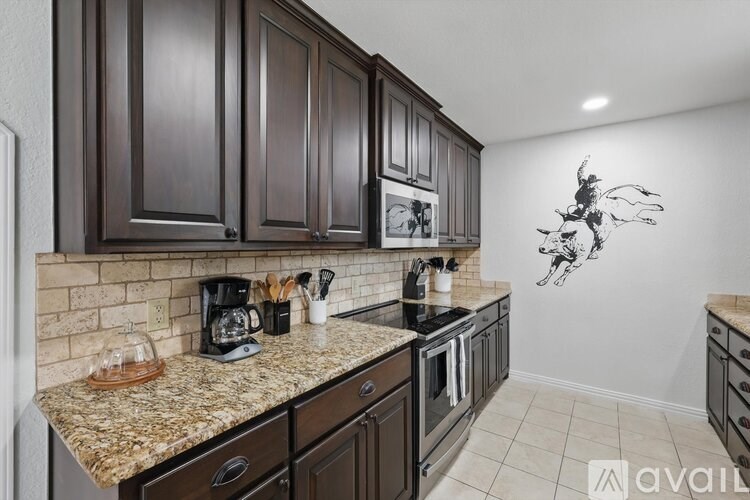 A kitchen with brown cabinets and granite countertops.