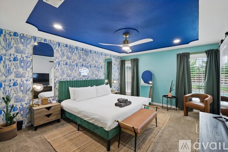 A bedroom with a bed, a chair, and a ceiling fan.