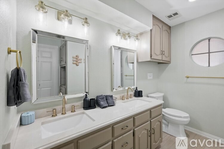 A bathroom with a toilet, sink, and mirror.