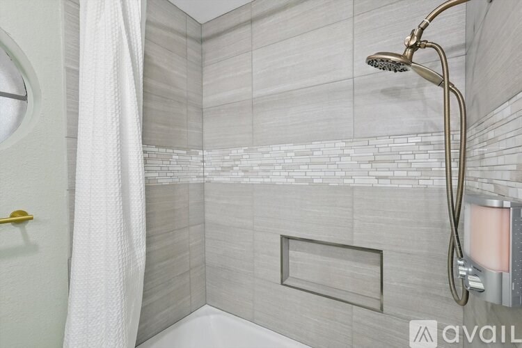 A modern bathroom with a white shower curtain and a glass shower door.