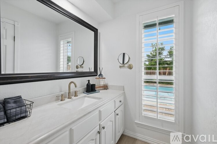 A bathroom with a white sink and a mirror above it.