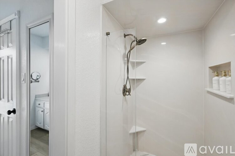 A white bathroom with a shower and a door.