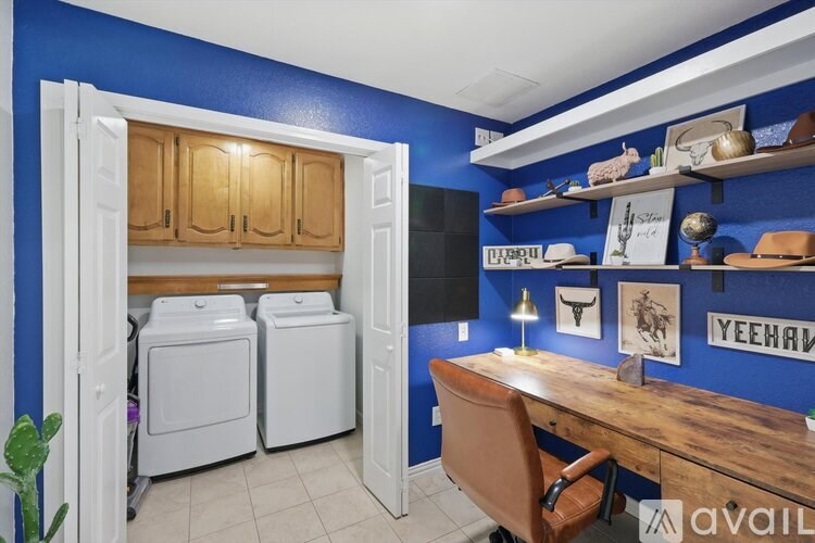 A room with blue walls and a wooden desk with a chair.