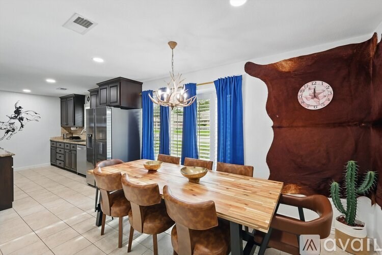 A modern dining room with a wooden table and chairs.