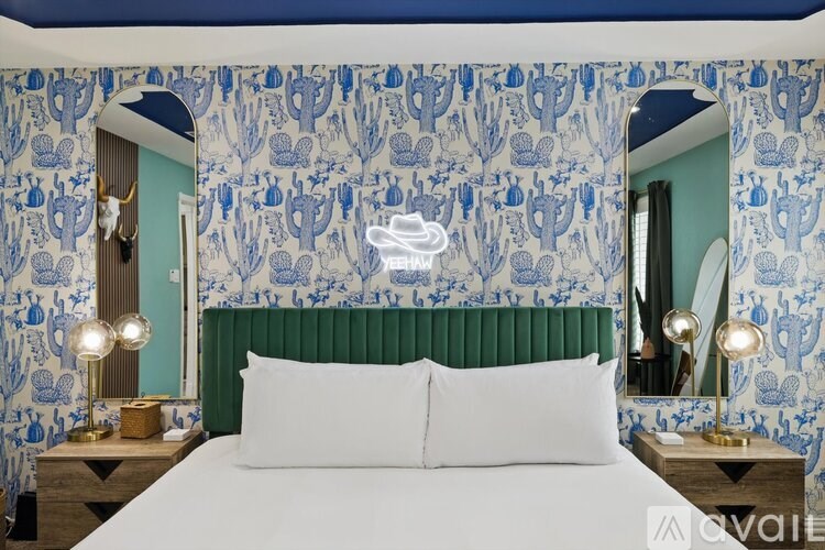 A bedroom with a bed, two lamps, and a mirror.