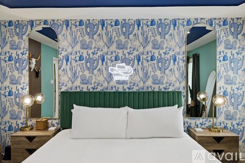 A bedroom with a bed, two lamps, and a mirror.