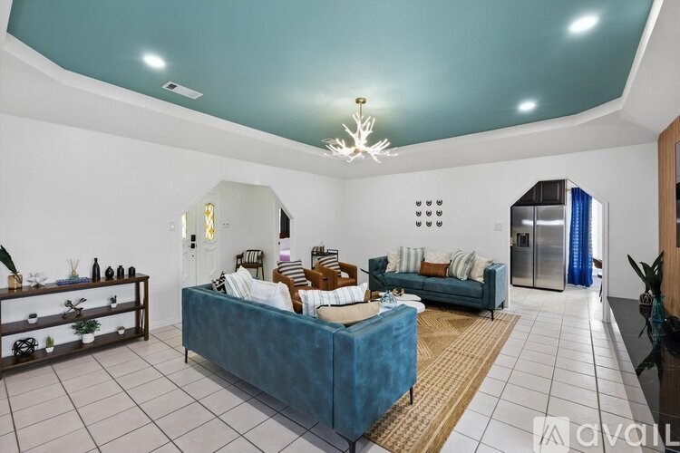 A living room with a blue couch and a chandelier.