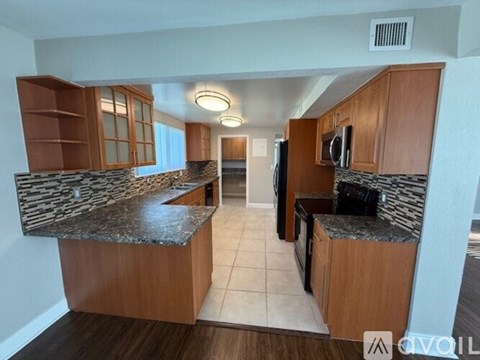 A kitchen with wooden cabinets and a granite countertop.