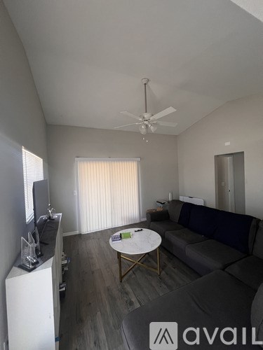 A living room with a grey couch and a white coffee table.