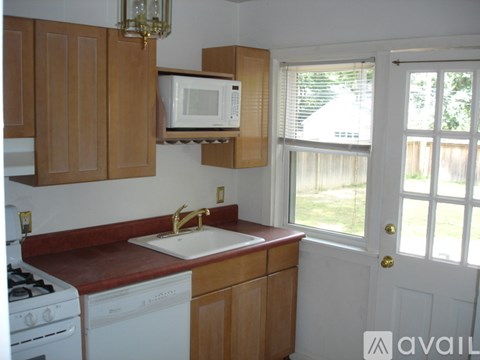 A kitchen with wooden cabinets and a white sink.
