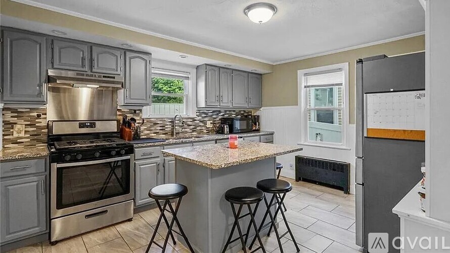 A kitchen with a granite countertop and stainless steel appliances.