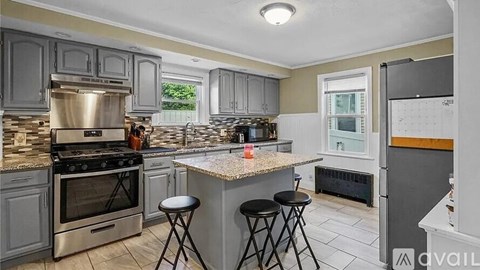 A kitchen with a granite countertop and stainless steel appliances.