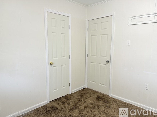 A bathroom with a white pedestal sink, a mirror, a toilet, and a shower with a glass door.