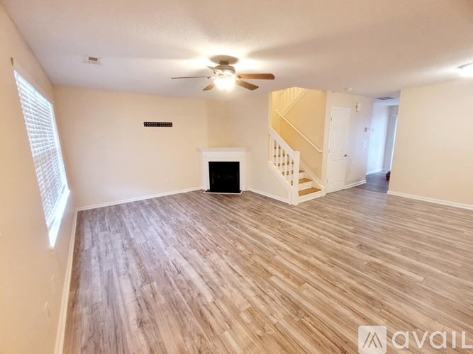 A living room with a fireplace and a staircase.