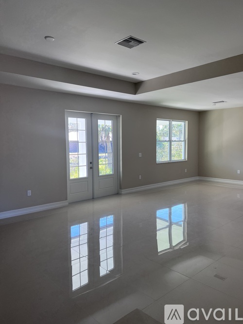 A spacious room with a large window and a door.