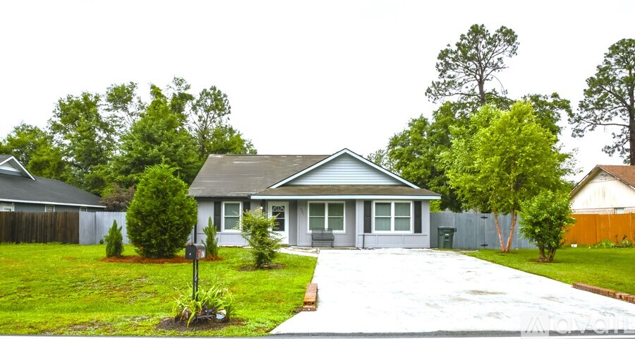 A house with a grey roof and a white fence.