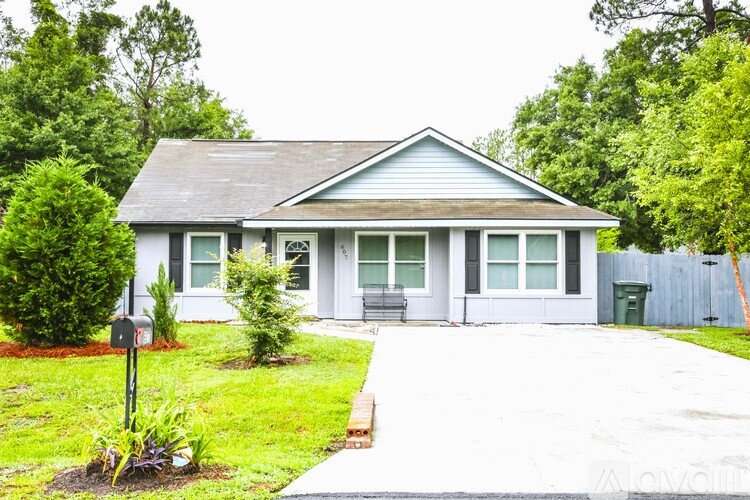 A house with a grey roof and a mailbox in front.