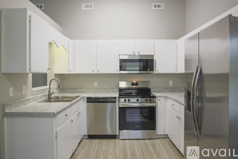 A modern kitchen with white cabinets and stainless steel appliances.