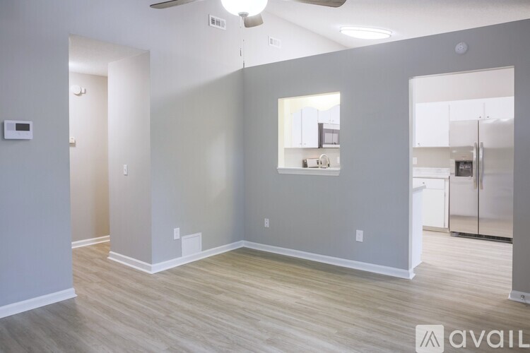 A spacious room with wooden flooring and a ceiling fan.