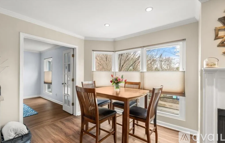 A dining room with a wooden table and chairs.