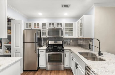 A kitchen with white cabinets and stainless steel appliances.