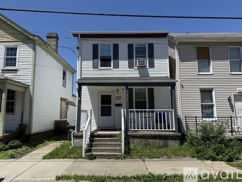 A two-story house with a porch and a front door.