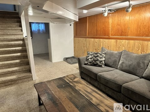 A living room with a grey couch and a wooden coffee table.