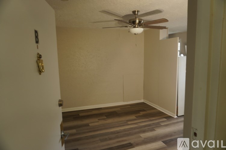 A room with a ceiling fan and a statue on the wall.