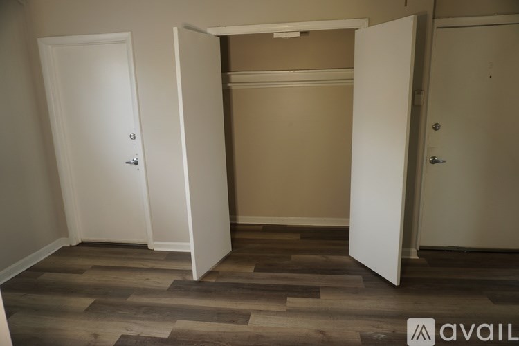 A room with three doors and a wooden floor.