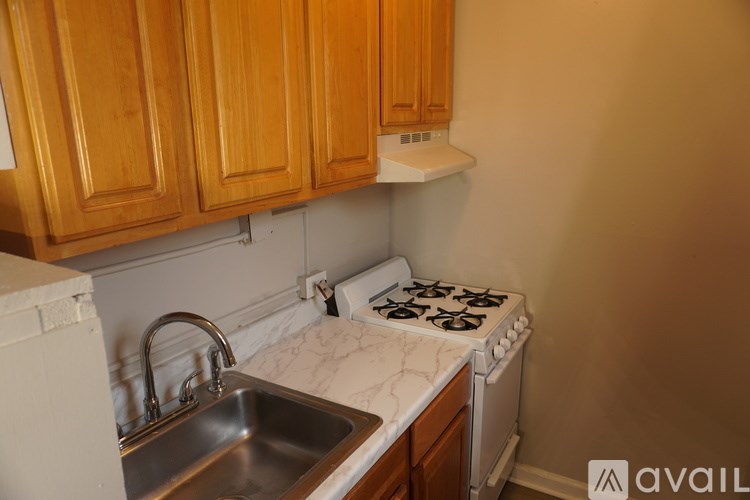 A kitchen with wooden cabinets and a white stove top oven.