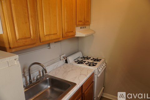 A kitchen with wooden cabinets and a white stove top oven.